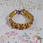 Bracelet Soleil mont&eacute; avec des facettes en verre de boh&egrave;me aux couleurs Topaze AB &agrave; laquelle s&rsquo;ajoute des perles rondes nacr&eacute;es Gold et Maron o&ugrave; elles s&rsquo;entrelacent avec les rocailles Dor&eacute;es satin&eacute;es
